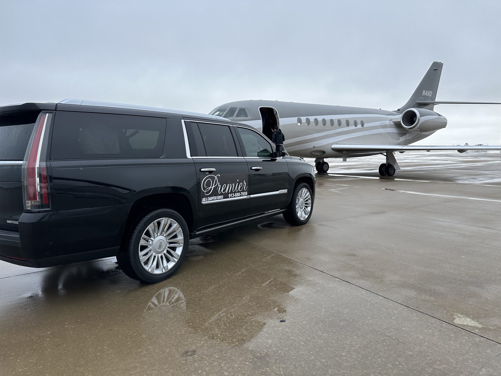 Premier Plus black Cadillac Escalade beside a private jet on the tarmac